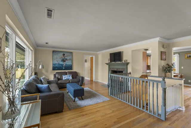 a living room with furniture a flat screen tv and a wooden floor