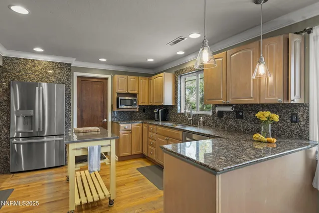 a kitchen with stainless steel appliances granite countertop a sink refrigerator and cabinets
