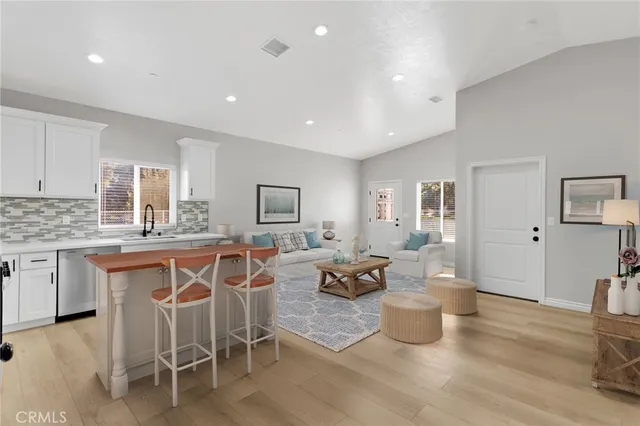 a living room with furniture a wooden floor and a sink