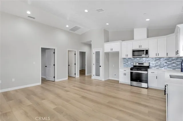 a large kitchen with cabinets and stainless steel appliances