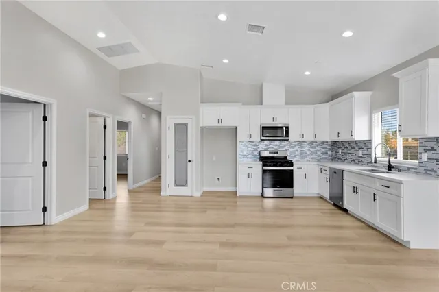 a large kitchen with cabinets stainless steel appliances and a counter top space