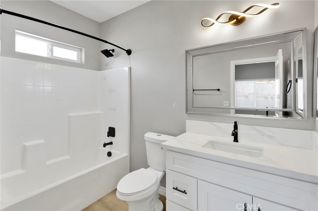 16150 Smoke Tree Street Hesperia, CA 92345 - Photo 21 of 32 a bathroom with a sink a toilet and a mirror