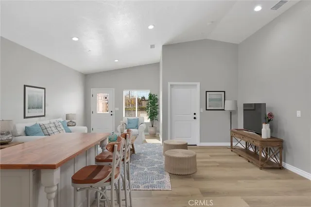 a living room with furniture a flat screen tv and a table