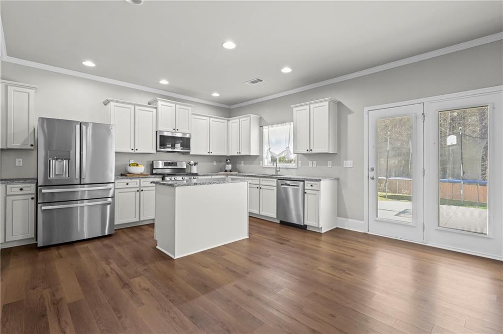 780 Springs Crest Drive Dallas, GA 30157 - Photo 12 of 47 a kitchen with white cabinets and stainless steel appliances