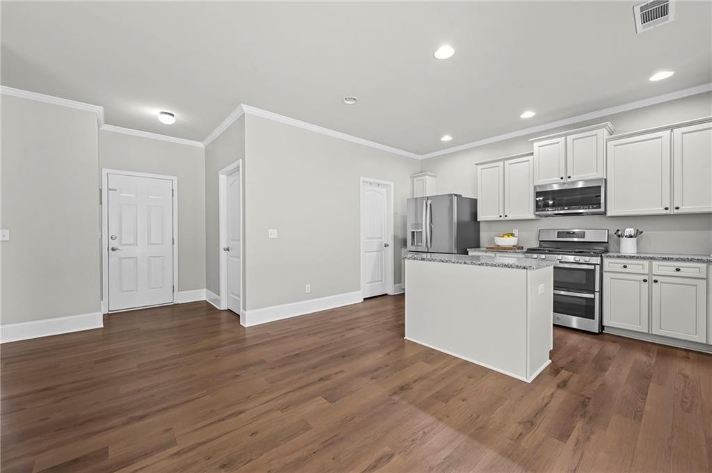 780 Springs Crest Drive Dallas, GA 30157 - Photo 13 of 47 a kitchen with wooden floors and white appliances