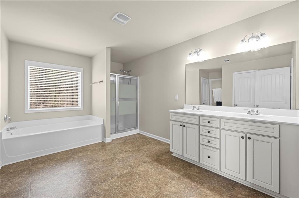 780 Springs Crest Drive Dallas, GA 30157 - Photo 23 of 47 a spacious bathroom with a double vanity sink a large mirror and a bathtub