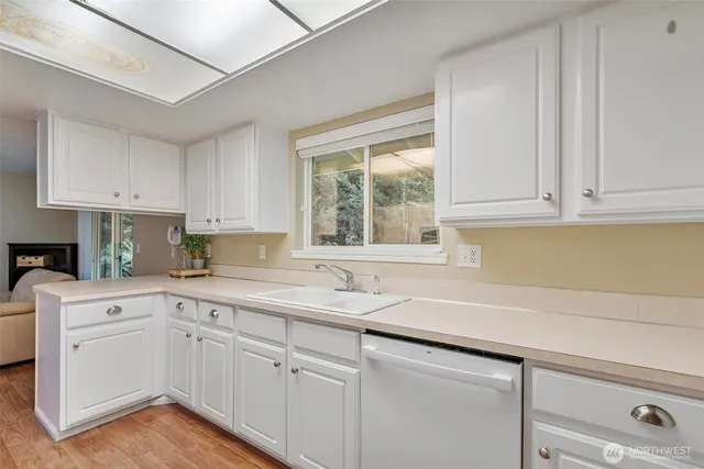 a kitchen with white cabinets white appliances and a sink