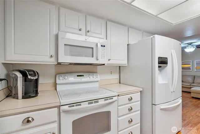 a kitchen with appliances a refrigerator and cabinets