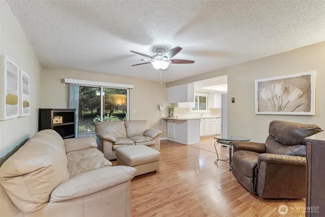 a living room with furniture ceiling fan and a rug