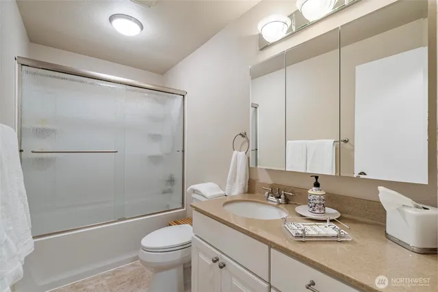 a bathroom with a granite countertop sink toilet and shower