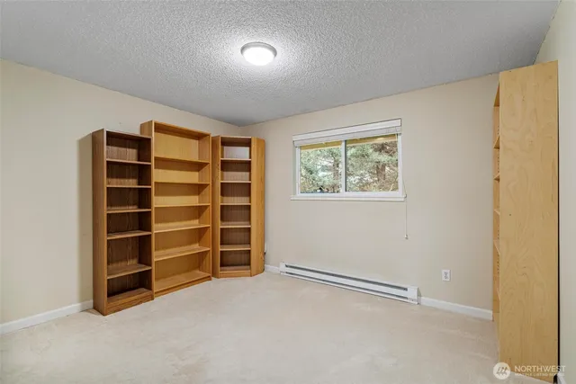a view of an empty room with a window and closet area