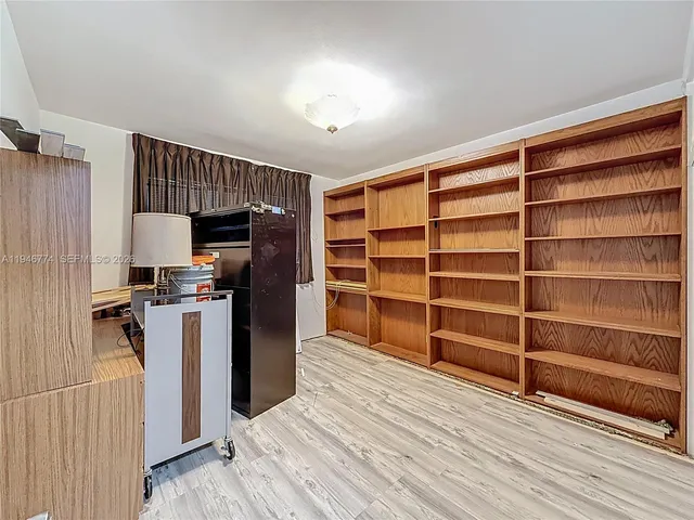 a view of a kitchen with refrigerator and wooden floor