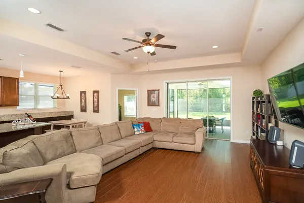 a living room with furniture kitchen view and a large window