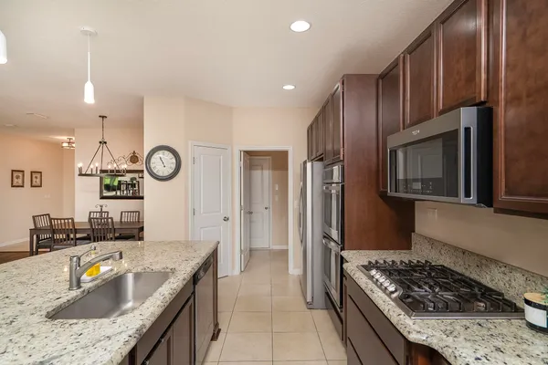 a kitchen with kitchen island a sink a stove and a refrigerator