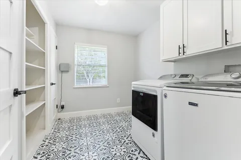 a utility room with stainless steel appliances granite countertop a sink stove and cabinets