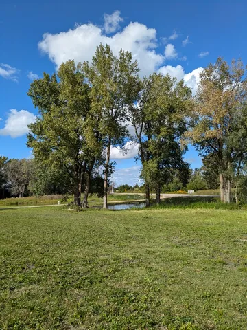 a sign that is sitting on a wooden bench in a yard