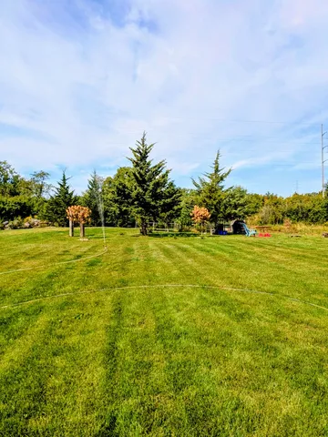 a view of yard with swimming pool and green space
