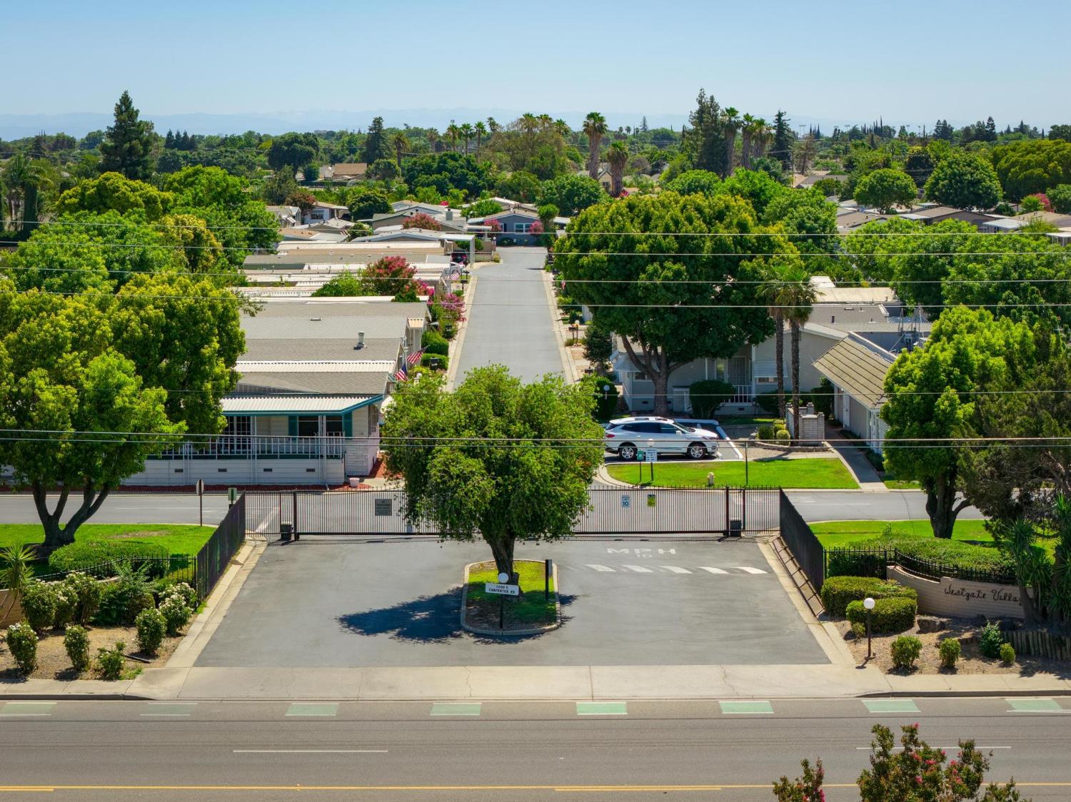 1200 South Carpenter Road, Unit 4 Modesto, CA 95351 - Photo 29 of 31 Gated community entrance with mature landscaping and paved roadways