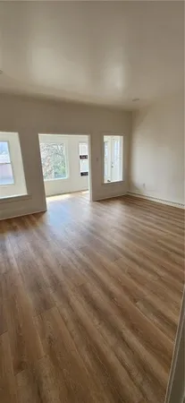 a view of an empty room with a fireplace and a window
