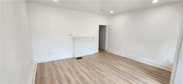 a view of a kitchen with refrigerator and wooden floor