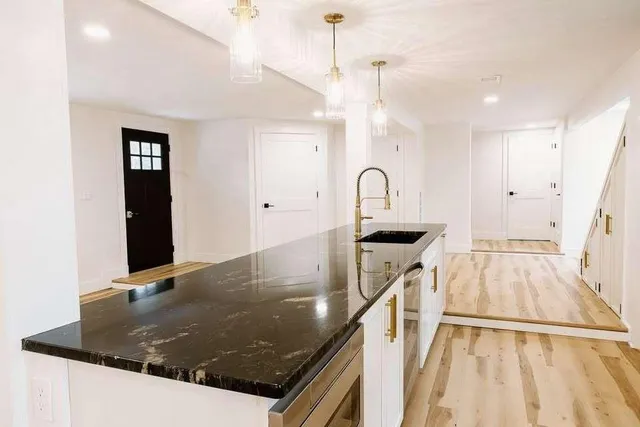a close view of a sink a counter space and a view of a living room