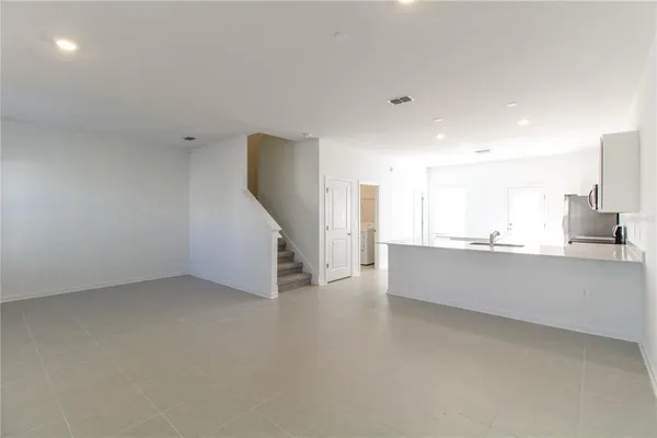 an empty room with a kitchen and windows