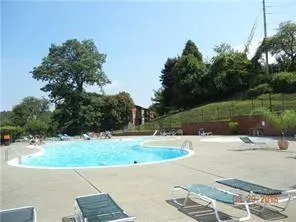 a kitchen with stainless steel appliances granite countertop a sink a stove top oven a chimney and a center island