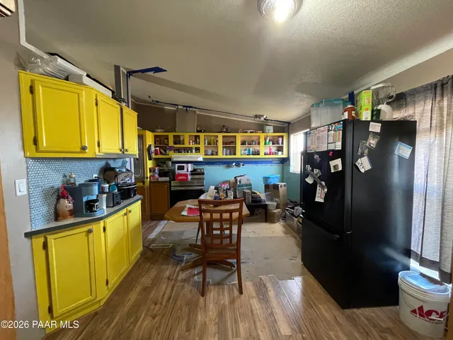 a kitchen with stainless steel appliances kitchen island granite countertop a refrigerator a stove and a wooden cabinets