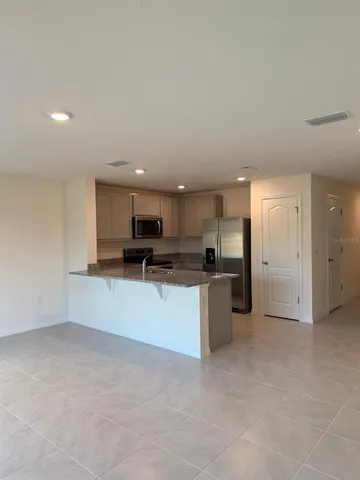 a view of kitchen with stainless steel appliances kitchen island a sink a refrigerator and a stove