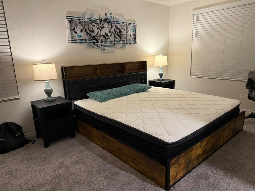 2914 Hudson Hammock Way St. Cloud, FL 34773 - Photo 22 of 30 a bed sitting in a bedroom and dressers next to a window