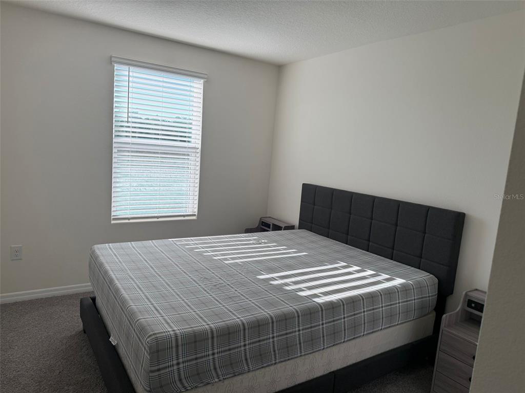 2914 Hudson Hammock Way St. Cloud, FL 34773 - Photo 30 of 30 a bed sitting in a bedroom next to a window