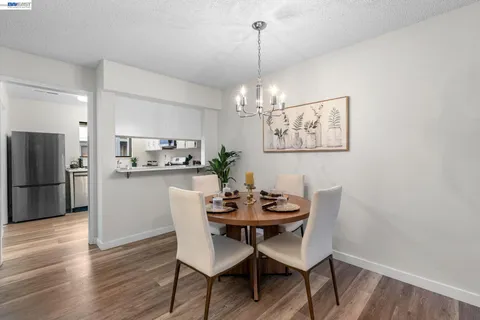 a dining room with furniture a chandelier and wooden floor