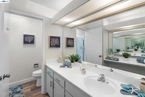 a bathroom with a double vanity sink toilet and mirror
