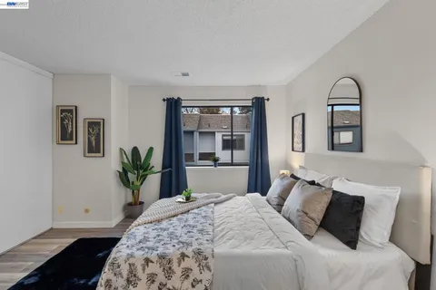 a bedroom with a large bed and a potted plant