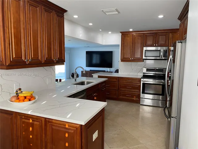 a kitchen with stainless steel appliances a stove a sink a microwave and cabinets