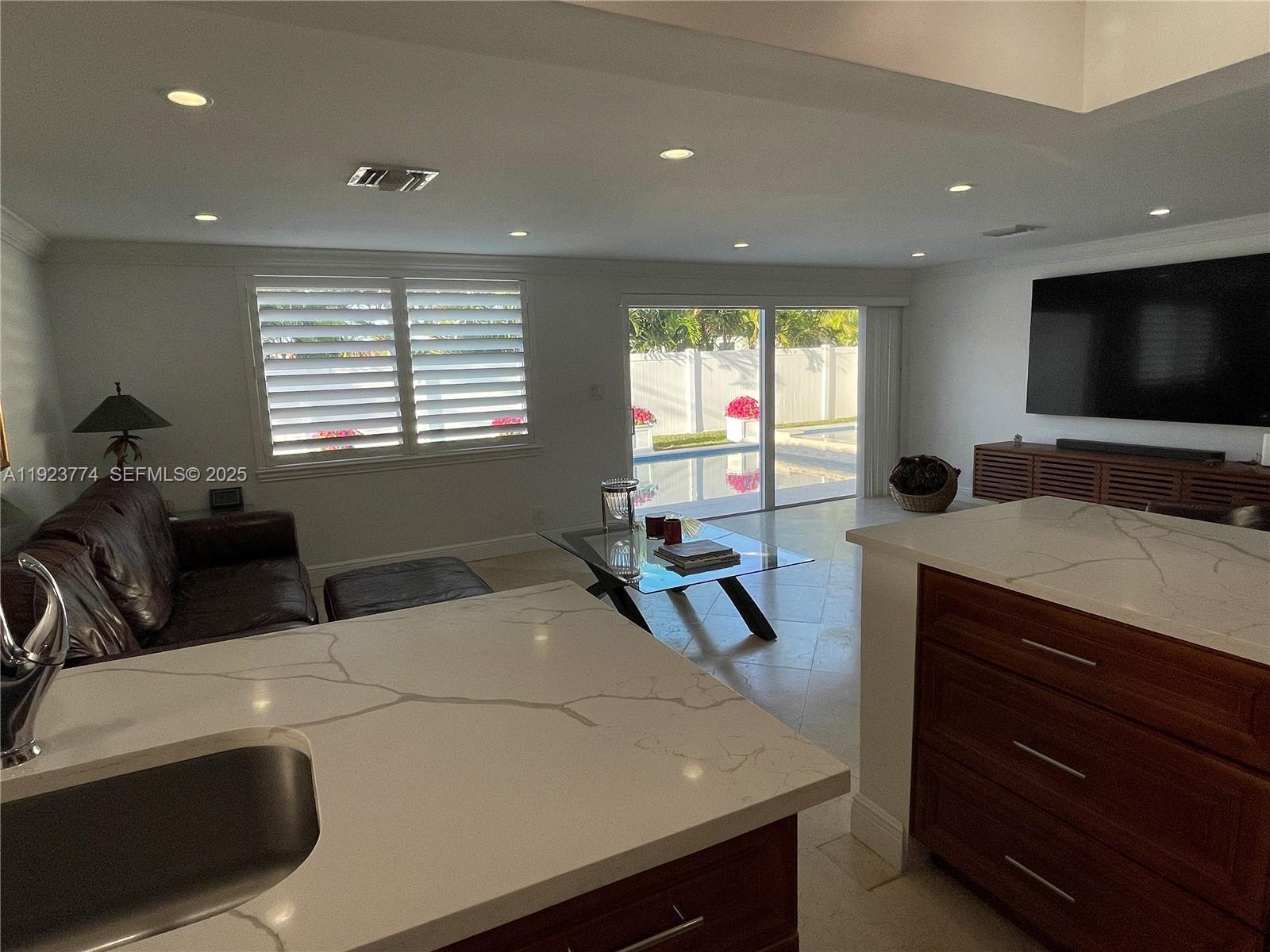 6611 Northeast 21st Lane Fort Lauderdale, FL 33308 - Photo 13 of 32 a living room with furniture a flat screen tv and a window