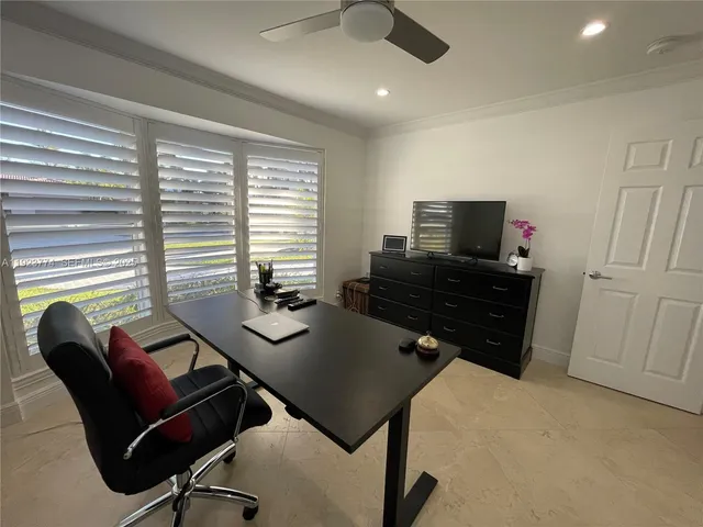 a view of a workspace with furniture and a window