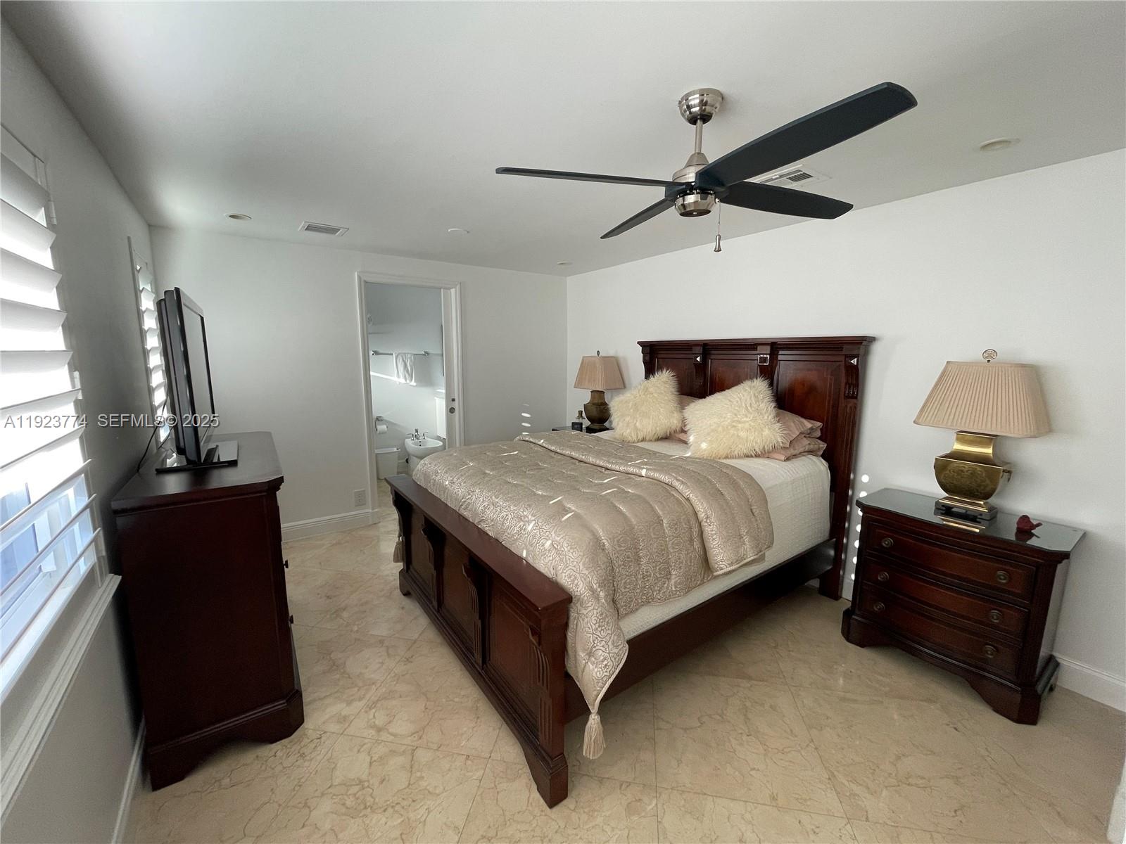 6611 Northeast 21st Lane Fort Lauderdale, FL 33308 - Photo 21 of 32 a bedroom with a bed and window