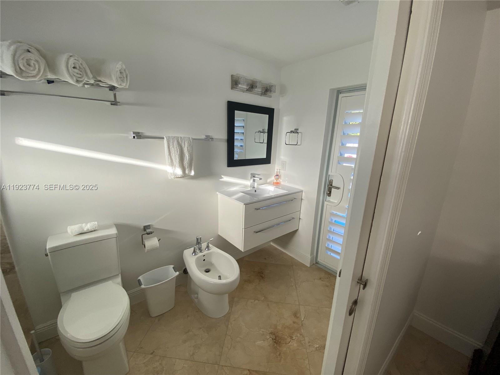 6611 Northeast 21st Lane Fort Lauderdale, FL 33308 - Photo 23 of 32 a bathroom with a granite countertop toilet and a sink