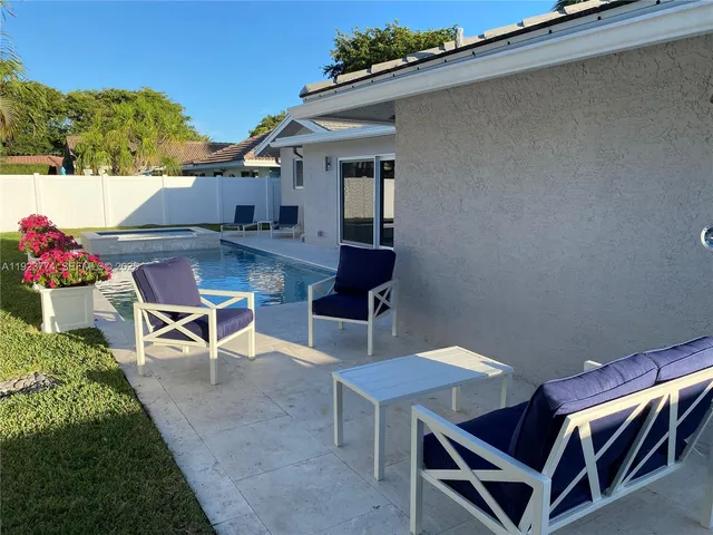 a backyard of a house with table and chairs