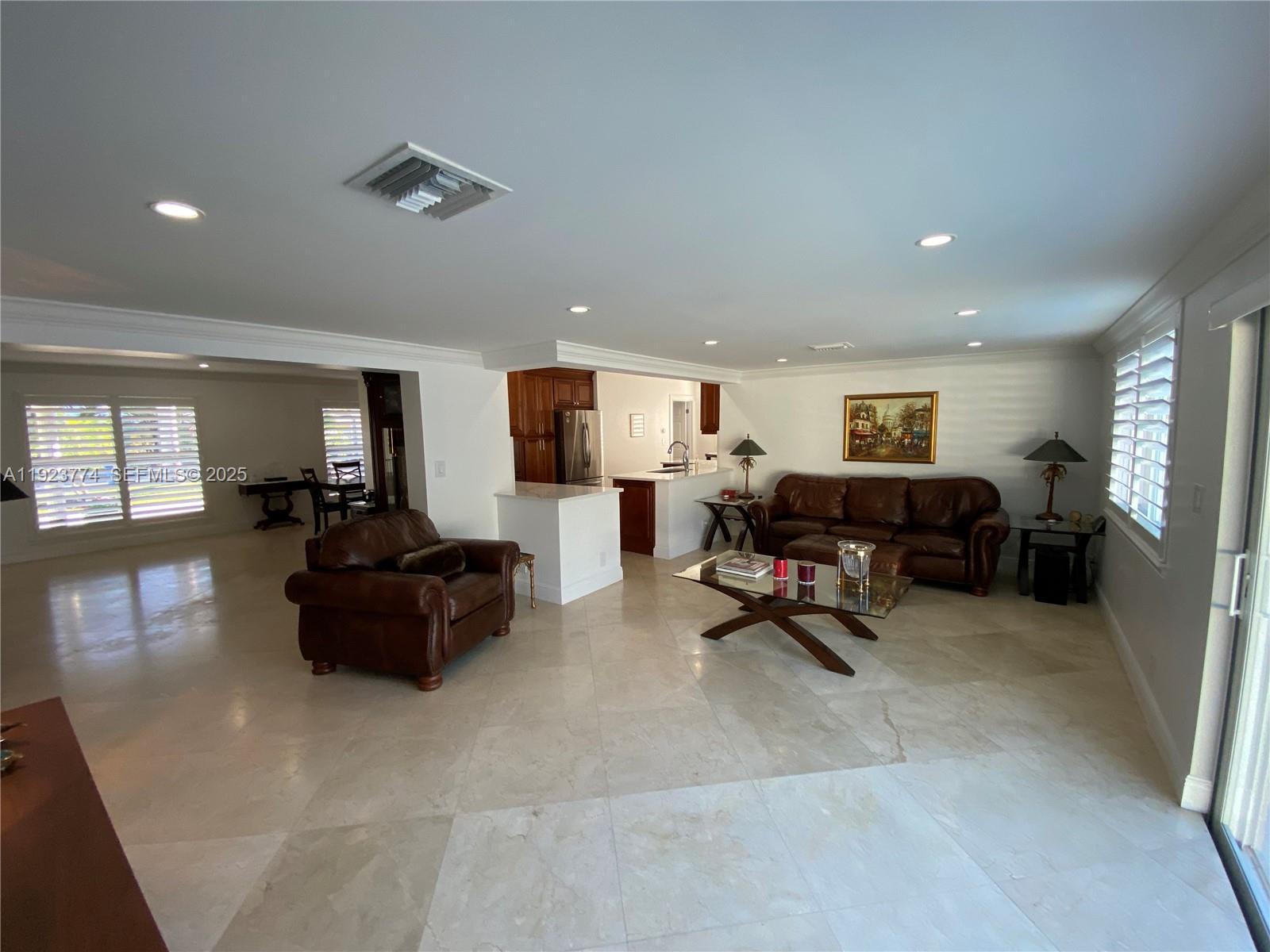 6611 Northeast 21st Lane Fort Lauderdale, FL 33308 - Photo 10 of 32 a living room with furniture and a dining table with kitchen view