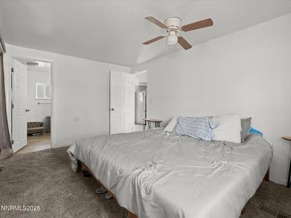a bedroom with a bed and a ceiling fan