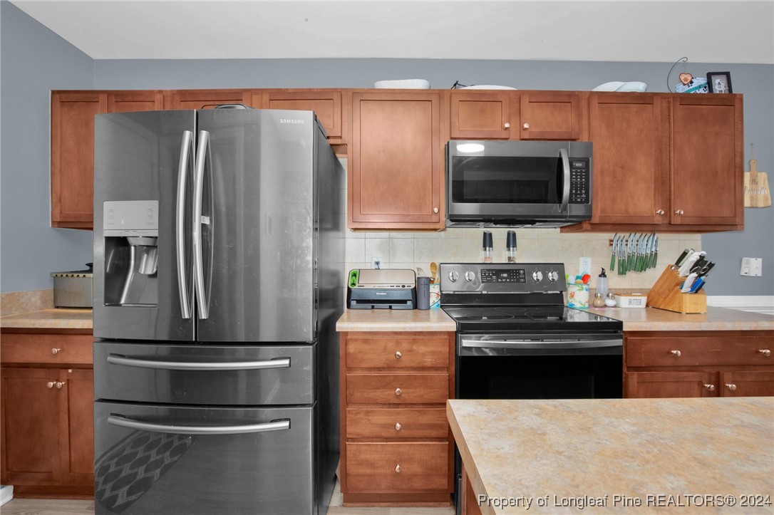 2124 Yellowbrick Road Fayetteville, NC 28314 - Photo 13 of 30 a kitchen with kitchen island a counter space a stove and a refrigerator