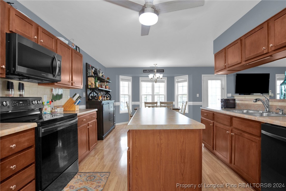 2124 Yellowbrick Road Fayetteville, NC 28314 - Photo 14 of 30 a large kitchen with stainless steel appliances granite countertop a sink dishwasher stove top oven a refrigerator with grey cabinets and wooden floor