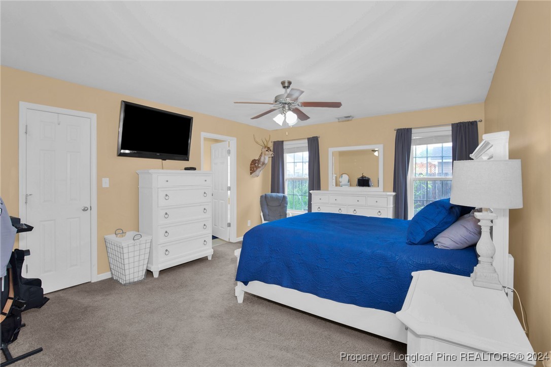 2124 Yellowbrick Road Fayetteville, NC 28314 - Photo 18 of 30 a bedroom with a bed a mirror on dresser and a flat screen tv