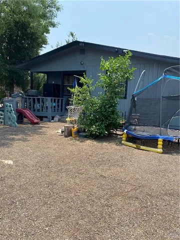 a backyard of a house with barbeque oven table and chairs