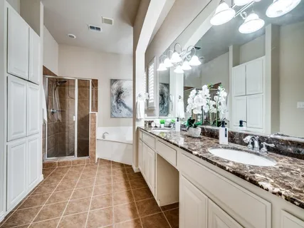 a bathroom with a granite countertop sink a toilet a mirror and shower