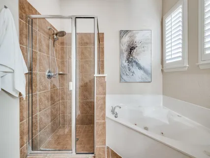 a bathroom with a bathtub a shower and a sink