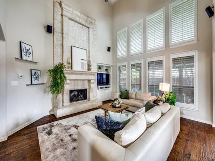 a living room with furniture large window and fireplace