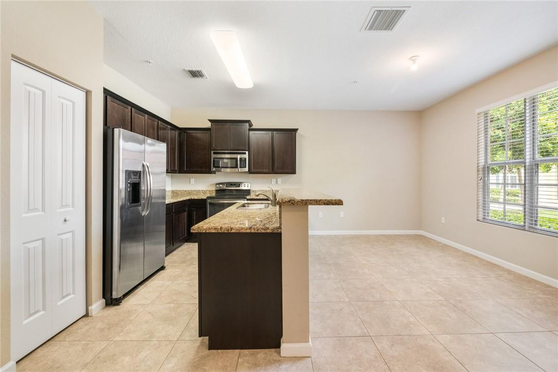 710 Southwest 1st Way Pompano Beach, FL 33060 - Photo 17 of 38 a kitchen with granite countertop a refrigerator and a stove top oven